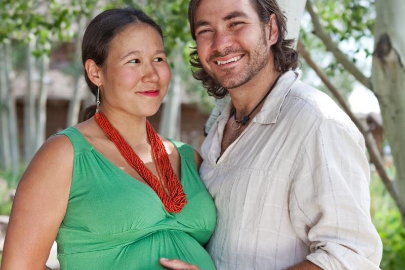 A pregnant woman is supported by her husband.