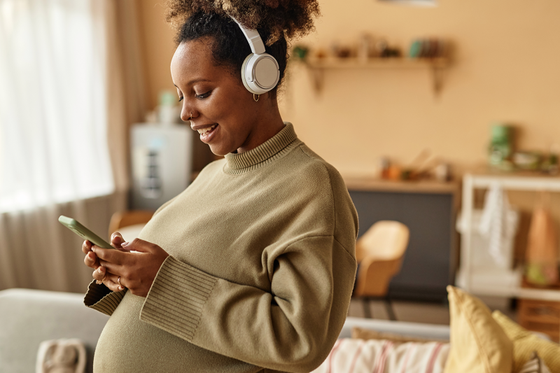 A pregnant woman uses a telehealth app on her cell phone to meet with a doula