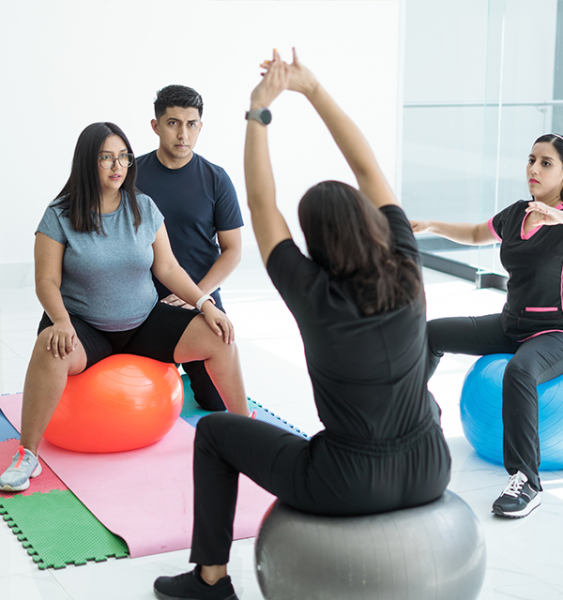 A doula guides a pregnant patient and their partner through physical exercises.