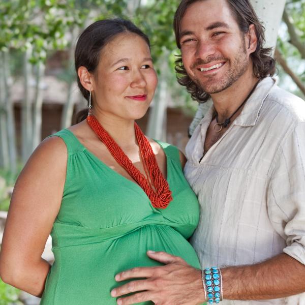 A pregnant woman is supported by her husband.