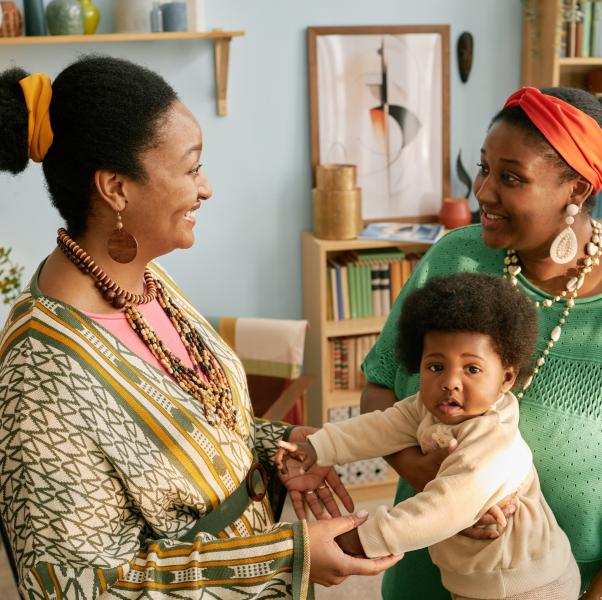 A midwife speaks with a mom and her infant in their home.