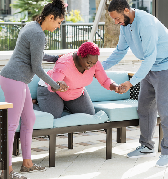 A doula helps a pregnant woman with exercises and her husband also supports her.