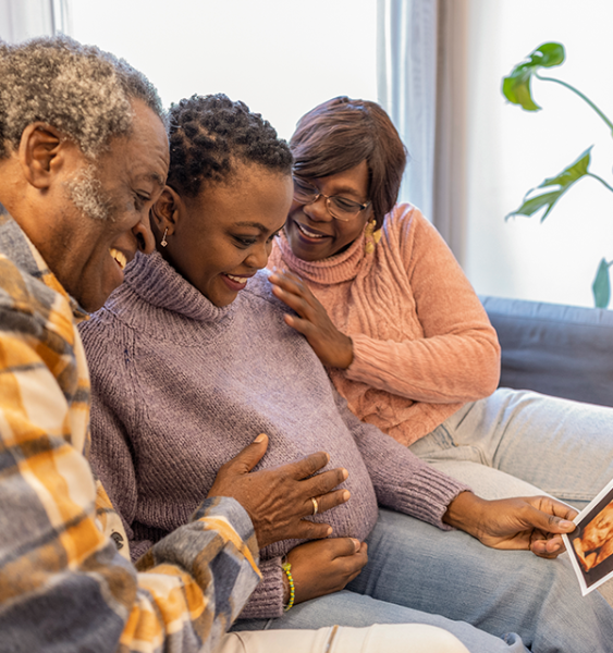A pregnant woman and her parents share excitement for her pregnancy.